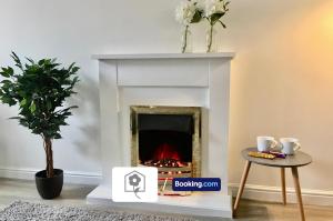 sala de estar con chimenea y mesa en Eastleigh House By Your Stay Solutions Short Lets & Serviced Accommodation Southampton With Free Wi-Fi & Close to Airport en Southampton