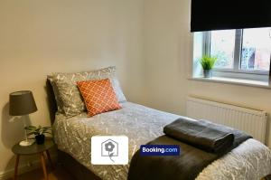 1 dormitorio con cama con almohada y ventana en Eastleigh House By Your Stay Solutions Short Lets & Serviced Accommodation Southampton With Free Wi-Fi & Close to Airport en Southampton