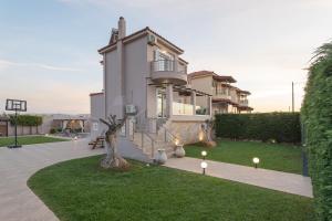 uma casa com uma árvore no meio de um quintal em Olea Serenity Villa em Loutraki