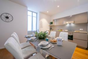 a kitchen and dining room with a table and white chairs at Star of Lugano in Lugano