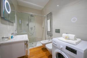 a white bathroom with a washing machine in it at Star of Lugano - Happy Rentals in Lugano