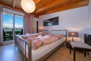 1 dormitorio con 1 cama grande y balcón en Little Love 207, en Caslano