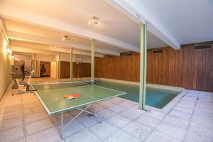 a ping pong table in a room with a pool at Casa Bader in Riva San Vitale