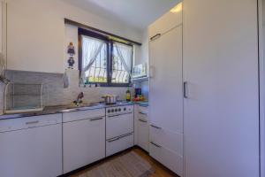 a kitchen with white cabinets and a white refrigerator at Villa Calella - Happy Rentals in Magliaso