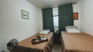 a bedroom with two beds and a window at Luxury Apartment Airport with Pool zona 12 Guatemala in Guatemala