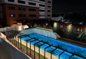 una piscina en la parte superior de un edificio por la noche en Apartamento en centro Ciudad de Guatemala z12 en Guatemala