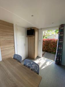 a room with a table and two chairs and a television at Camping L' Arlesienne in Arles