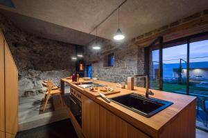 cocina con fregadero y pared de piedra en Villa Kambra With Whirlpool, en Dutovlje