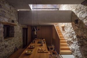 un comedor con una mesa larga y una pared de piedra en Villa Kambra With Whirlpool, en Dutovlje