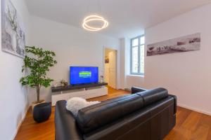 a living room with a black leather couch and a tv at Love of Lugano in Lugano