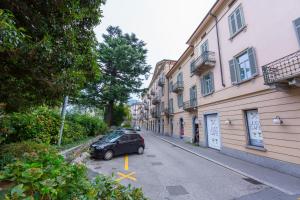 a car parked in a parking lot next to buildings at Love of Lugano - Happy Rentals in Lugano