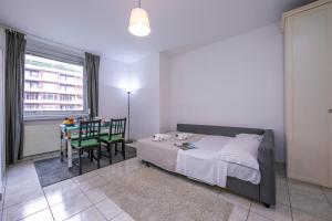 a bedroom with a bed and a table with a chair at Residence Palace - Happy Rentals in Lugano