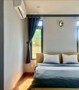 een slaapkamer met een bed en een raam bij Nomad Stay in Phan Rang