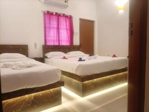 two beds in a hotel room with golditures at La Shashalia Luxury in Pondicherry