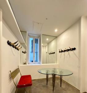 a dining room with a glass table and a red chair at PB suites in Florence