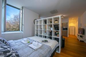 ein Schlafzimmer mit einem Bett und einem großen Fenster in der Unterkunft Little Lugano in Lugano