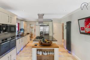 a kitchen with a bowl of fruit on a table at Luxury Ascot Home With Indoor Heated Pool & Cinema in Ascot