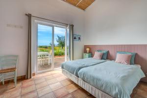1 dormitorio con 1 cama y puerta corredera de cristal en Quinta das Piteiras Turismo Rural, en Silves