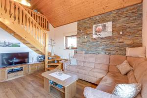 a living room with a brown couch and a brick wall at Vineyard Cottage Bahor - Happy Rentals in Črnomelj