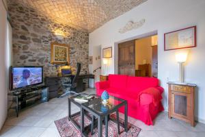 a living room with a red couch and a tv at Casa Tamè in Melide