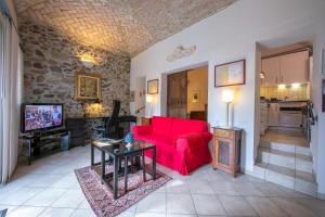 een woonkamer met een rode bank en een tv bij Casa Tamè in Melide