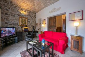 a living room with a red couch and a tv at Casa Tamè in Melide