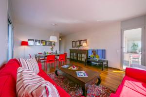 ein Wohnzimmer mit einem roten Sofa und einem Tisch in der Unterkunft La Maison du Bonheur - Happy Rentals in Aldesago