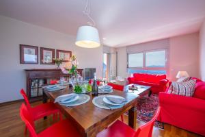 ein Wohnzimmer mit einem Holztisch und roten Stühlen in der Unterkunft La Maison du Bonheur - Happy Rentals in Aldesago