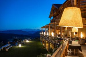 a hotel with a view of the mountains at night at Hotel Valentinerhof in Siusi