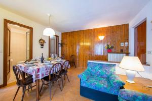 a dining room with a table and chairs and a couch at Bramé La Fam 32 few steps from skiing - Happy Rentals in Bardonecchia
