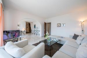a living room with white couches and a tv at Casa Monti Belvedere - Happy Rentals in Locarno
