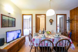 een eetkamer met een tafel met stoelen en een tv bij Bramé La Fam 32 few steps from skiing - Happy Rentals in Bardonecchia