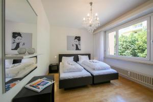 a bedroom with two beds and a chandelier at Casa Monti Belvedere - Happy Rentals in Locarno