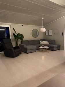 a living room with two couches and a table at Aurora panorama 2nd floor in Laksvatn