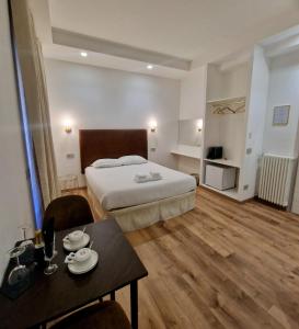 Habitación de hotel con cama y mesa en Cuma Suites, en Roma