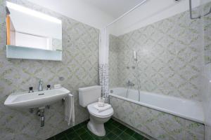 a bathroom with a toilet and a sink and a tub at Lido Apartment - Happy Rentals in Locarno
