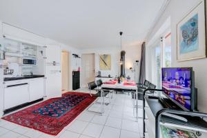 een keuken en een woonkamer met een tafel en een televisie bij Casa Brighella - Happy.Rentals in Brissago