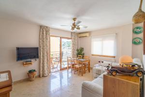 a living room with a couch and a tv at Rincón Playa, terraza y piscina in Rincón de la Victoria