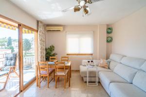 a living room with a couch and a table at Rincón Playa, terraza y piscina in Rincón de la Victoria