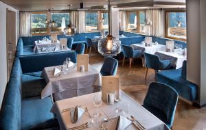 a restaurant with couches and tables and chairs at Hotel Valentinerhof in Siusi