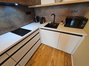 a kitchen with a sink and a microwave at Design apartmán Janské Lázně 1 - by AlkaTravel, Ski&Bike in Janske Lazne +45 photos