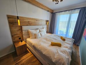 a bedroom with a large white bed with a window at Design apartmán Janské Lázně 1 - by AlkaTravel, Ski&Bike in Janske Lazne