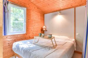 a bedroom with a bed with a table on it at Camping LA SERRE in Aigues-Vives