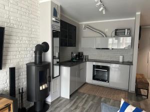 a kitchen with white cabinets and a stove in it at Latarnia Morska in Jantar