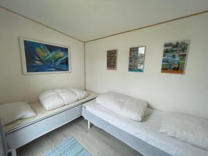 2 Betten in einem Zimmer mit weißen Wänden in der Unterkunft Sovgodt Nyord in Nyord
