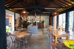 a restaurant with wooden tables and chairs and windows at Pousada Vidinha Bela in Brazópolis