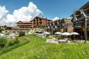 Hotel Valentinerhof في سويسي: منتجع فيه حديقة فيها مظلات ومباني