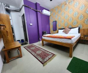 a bedroom with a bed and a purple wall at The kashi palace inn ,Varanasi ! fully-Air-Conditioned hotel at prime location with Parking availability, near Kashi Vishwanath Temple, and Ganga ghat in Varanasi