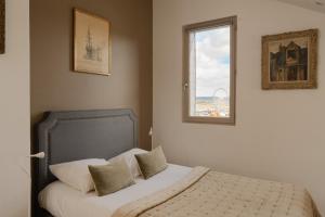 a bed in a bedroom with a window at Studio et appartements Sainte Catherine in Honfleur