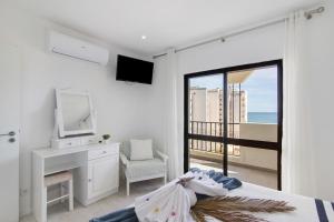 um quarto com uma cama, uma secretária e uma televisão em Luxury Beach View - Praia da Rocha em Portimão